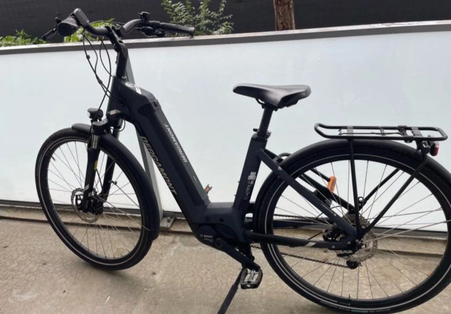 Vélo électrique urbain à cadre bas, noir avec porte-bagages.